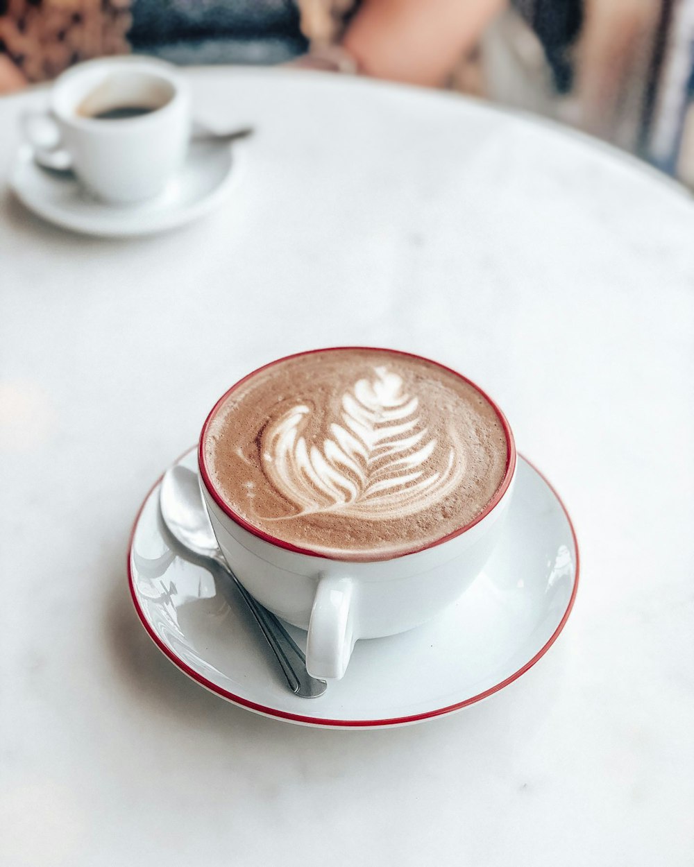 Tasse en céramique blanche avec soucoupe sur table blanche