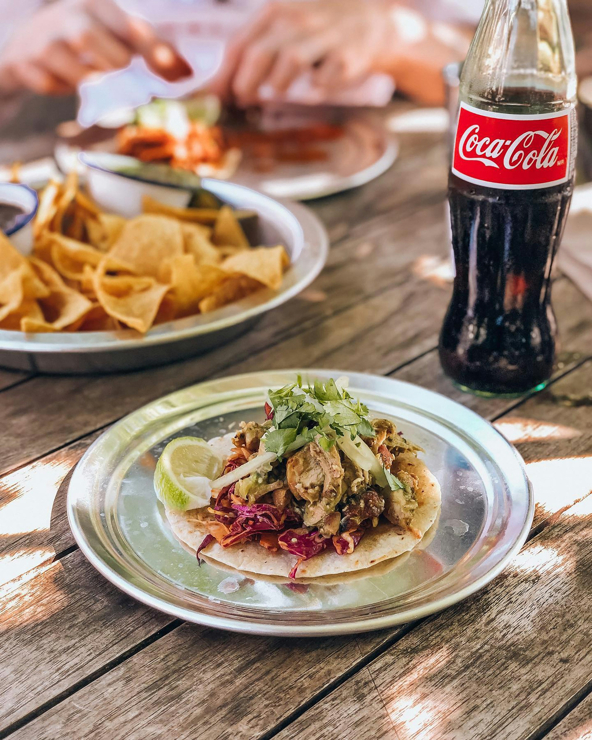 Close-up of a sizzling plate with tacos and fries, showcasing the fresh ingredients and bold flavors that define Coco Loco Chiringuito's menu.