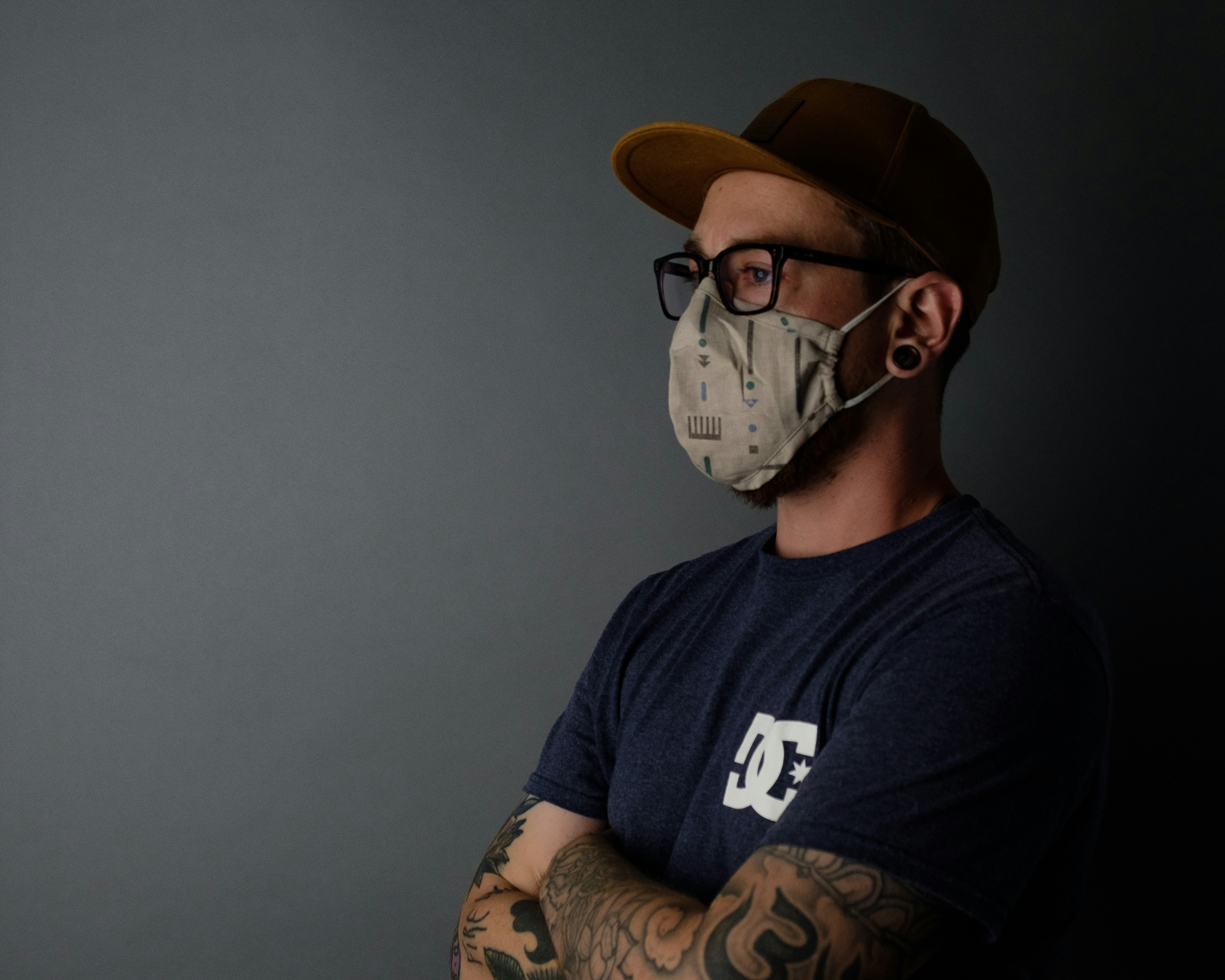 man in black crew neck t-shirt wearing brown cap and sunglasses