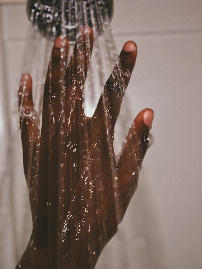 a women hand in the shower while washing her hair