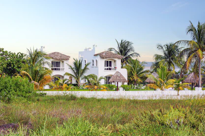 white and brown house surrounded by green grass field during daytime