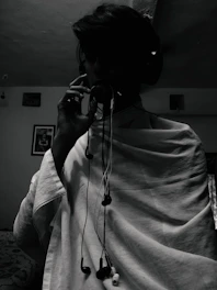 An artist wearing headphones, surrounded by vintage microphones and sound equipment.