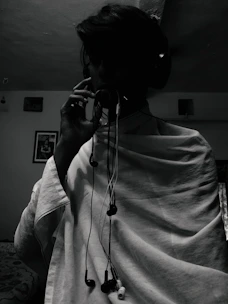 An artist wearing headphones, surrounded by vintage microphones and sound equipment.
