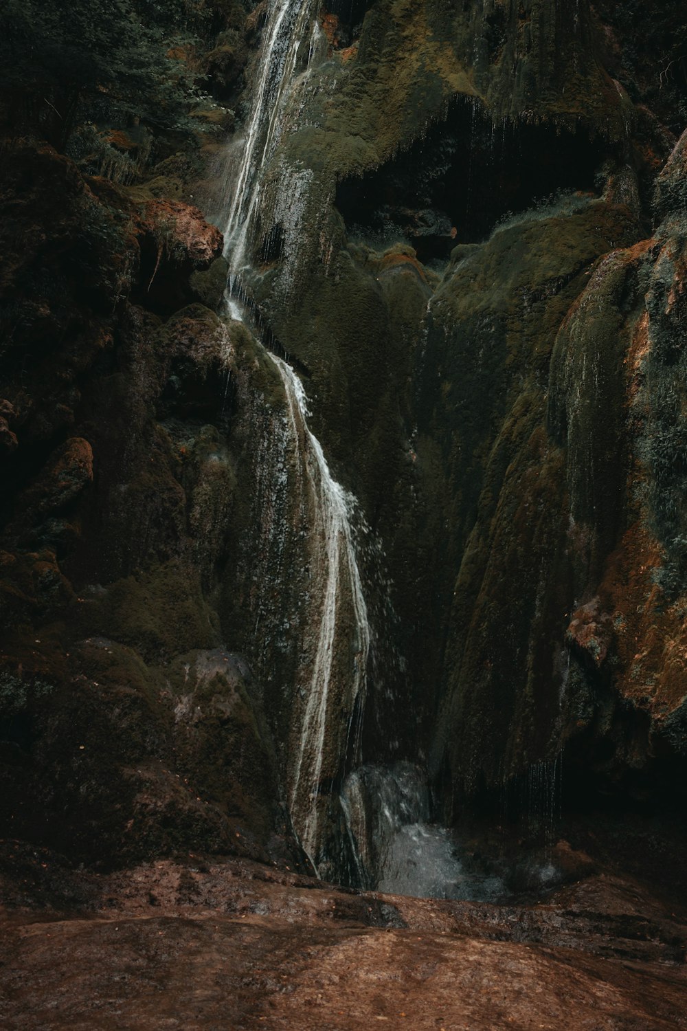 water falls on brown rocky mountain