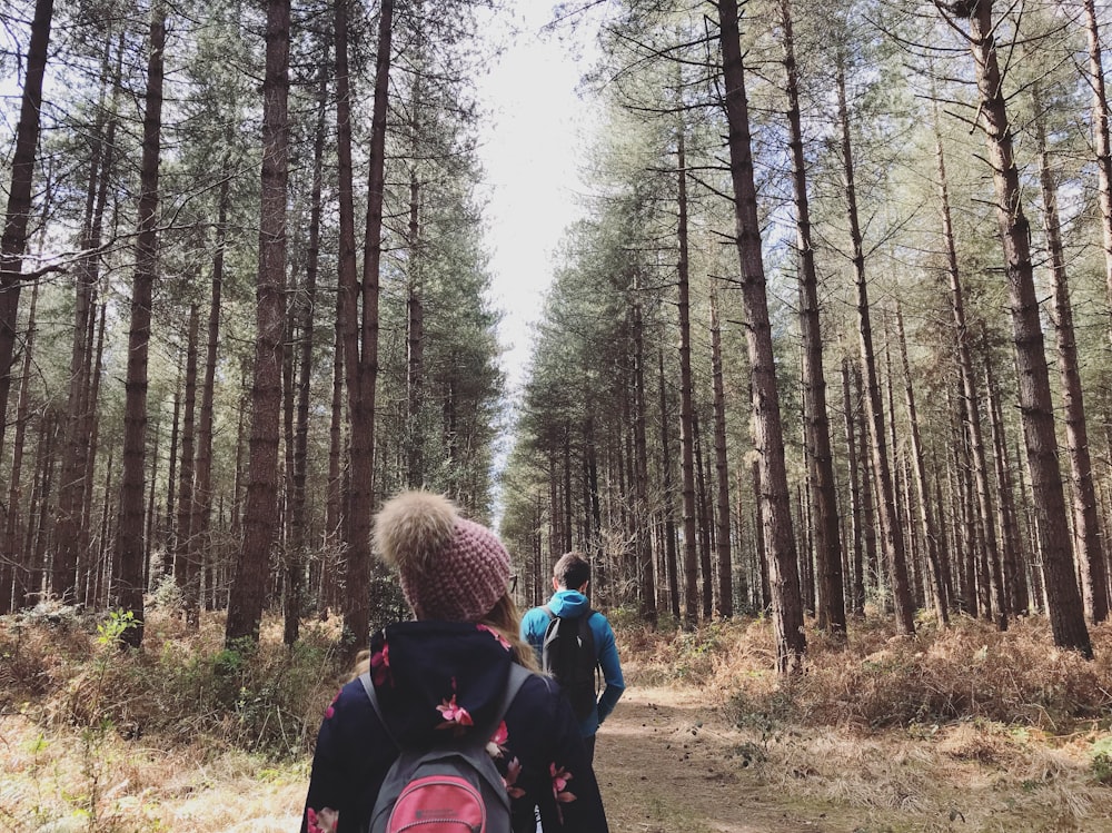 man in black jacket carrying black backpack in forest during daytime