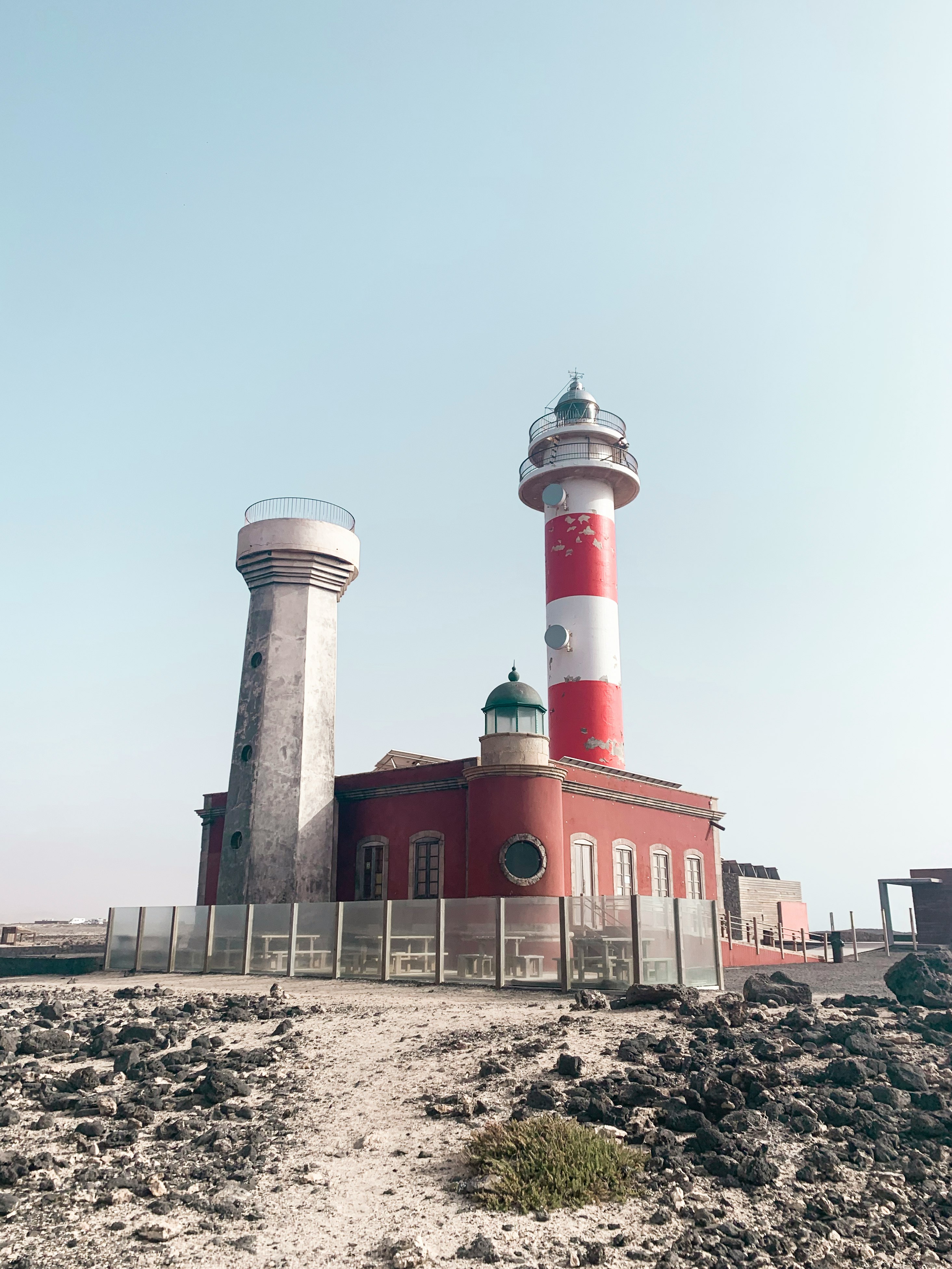 red and white concrete building near body of water during daytime