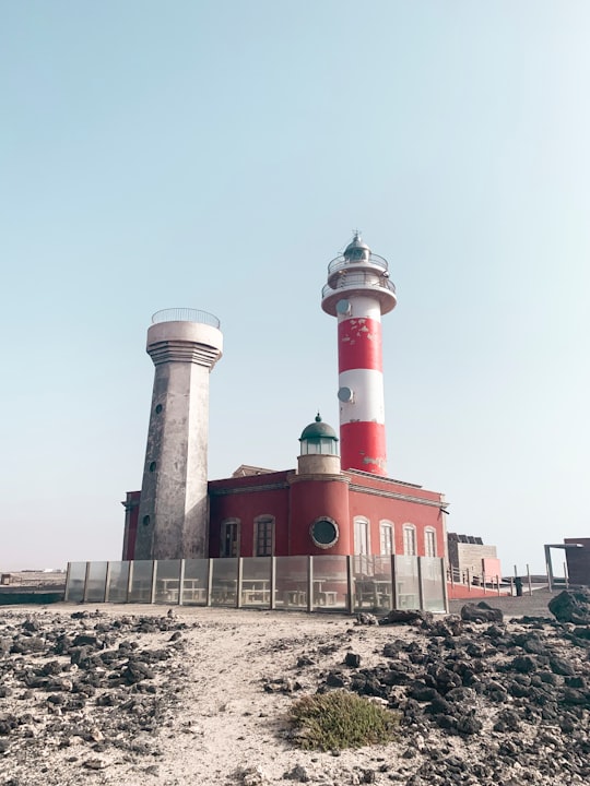 red and white concrete building near body of water during daytime in Fuerteventura Spain