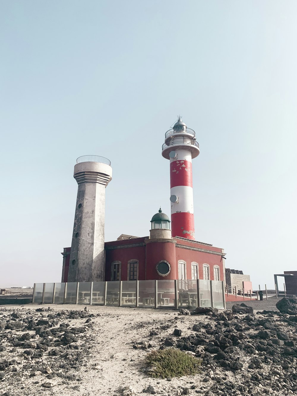 Bâtiment en béton rouge et blanc près d’un plan d’eau pendant la journée