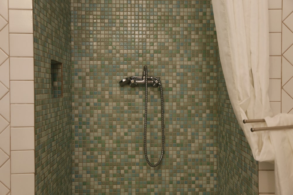 stainless steel shower head on brown and white wall tiles