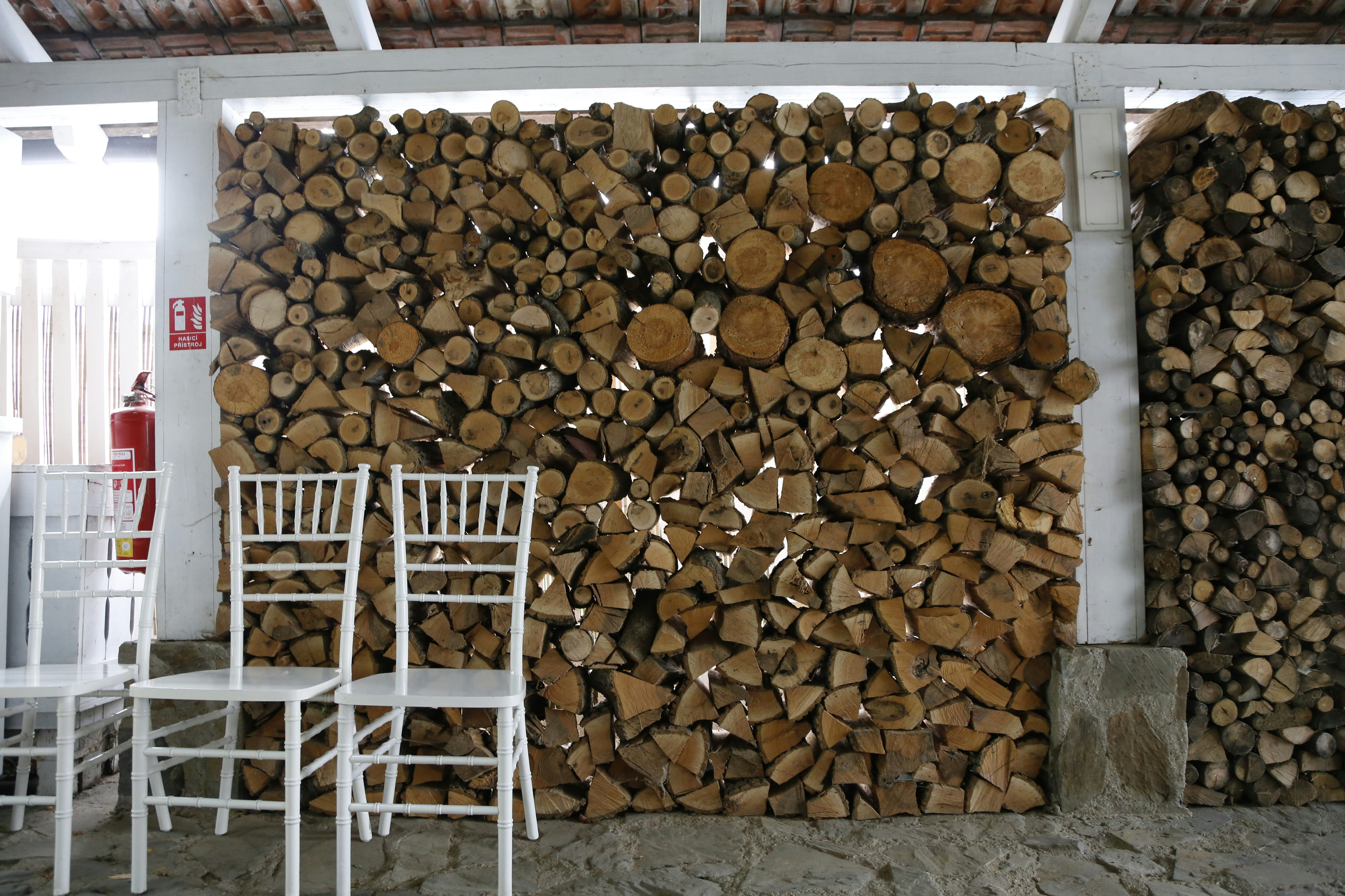 white wooden chair beside brown firewood