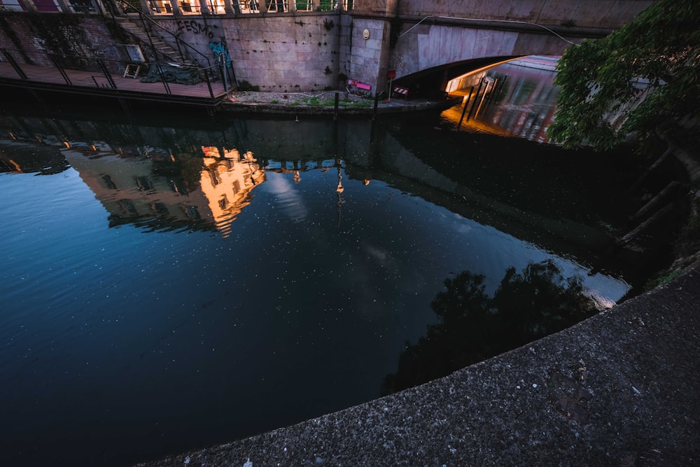 Plan d’eau près d’un bâtiment en béton brun pendant la journée