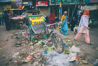 A colorful street in India bustling with tourists and decorated rickshaws.