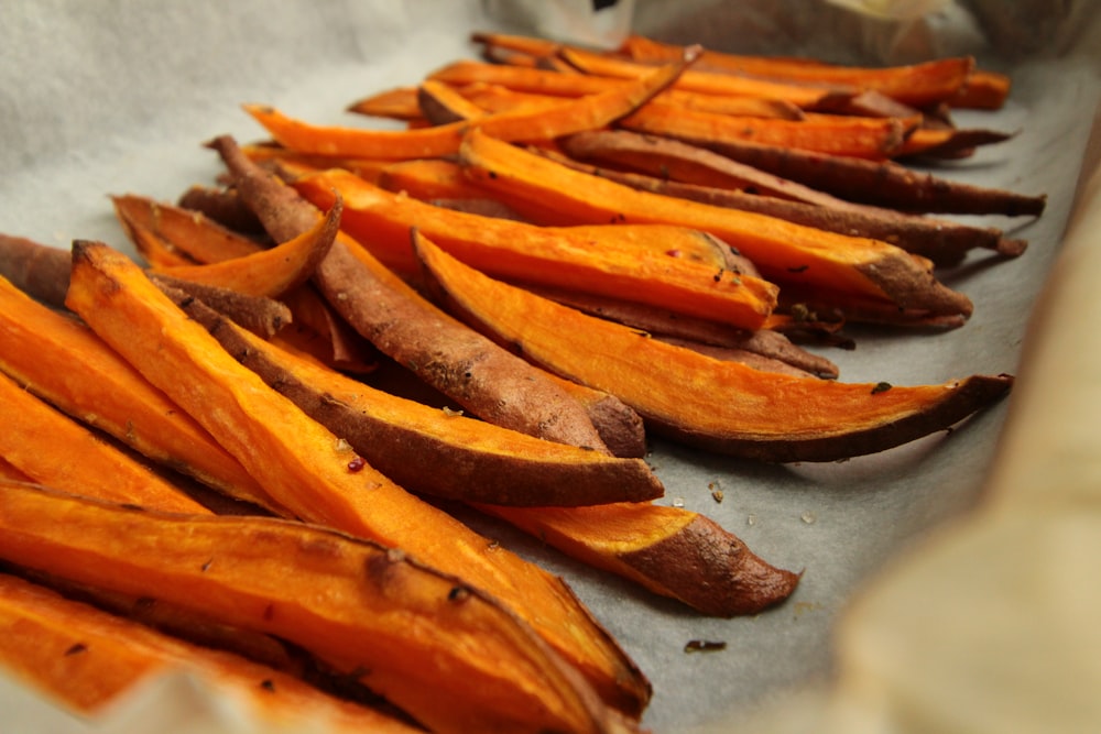 Fruta naranja en rodajas sobre mesa blanca