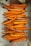 Numerous baked sweet potato fries are arranged on a baking sheet lined with parchment paper. The fries are cut into thick, rustic slices, showcasing a vibrant orange interior and slightly browned edges.