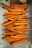 Numerous baked sweet potato fries are arranged on a baking sheet lined with parchment paper. The fries are cut into thick, rustic slices, showcasing a vibrant orange interior and slightly browned edges.