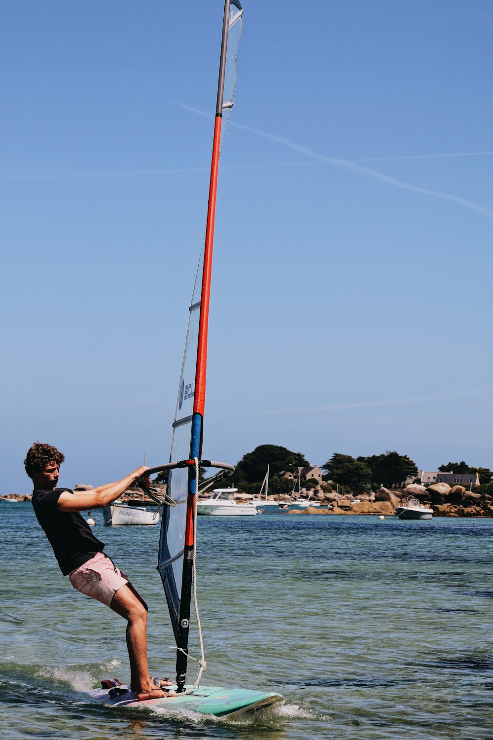 woman in black tank top and pink shorts standing on the boat during daytime