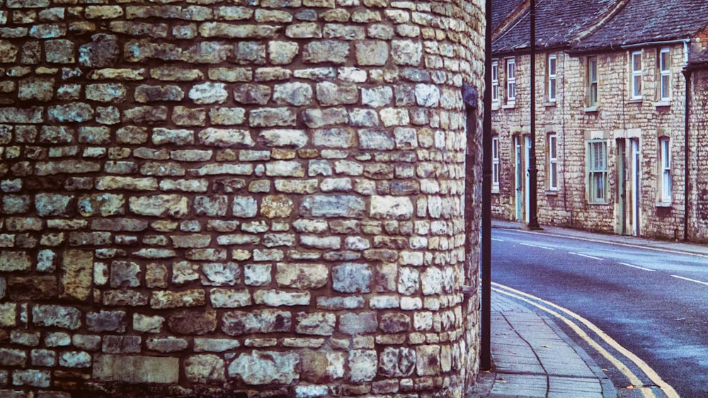 brown brick wall near road during daytime