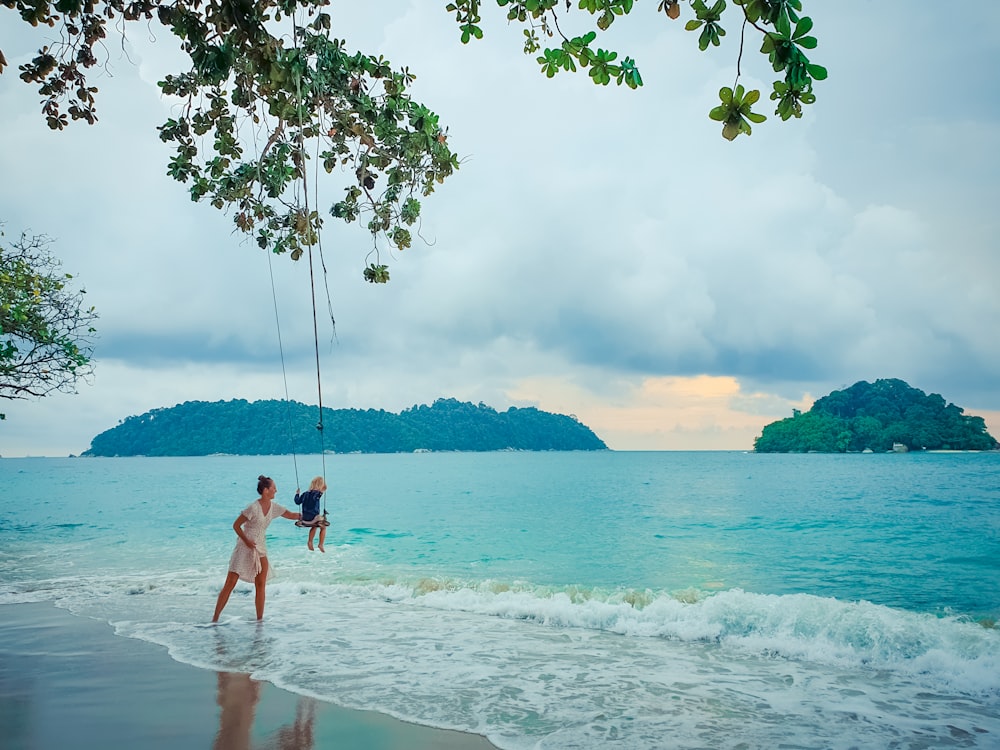 2 boys playing on beach during daytime