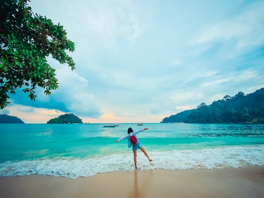 woman in red bikini standing on beach during daytime in Pangkor Island Malaysia