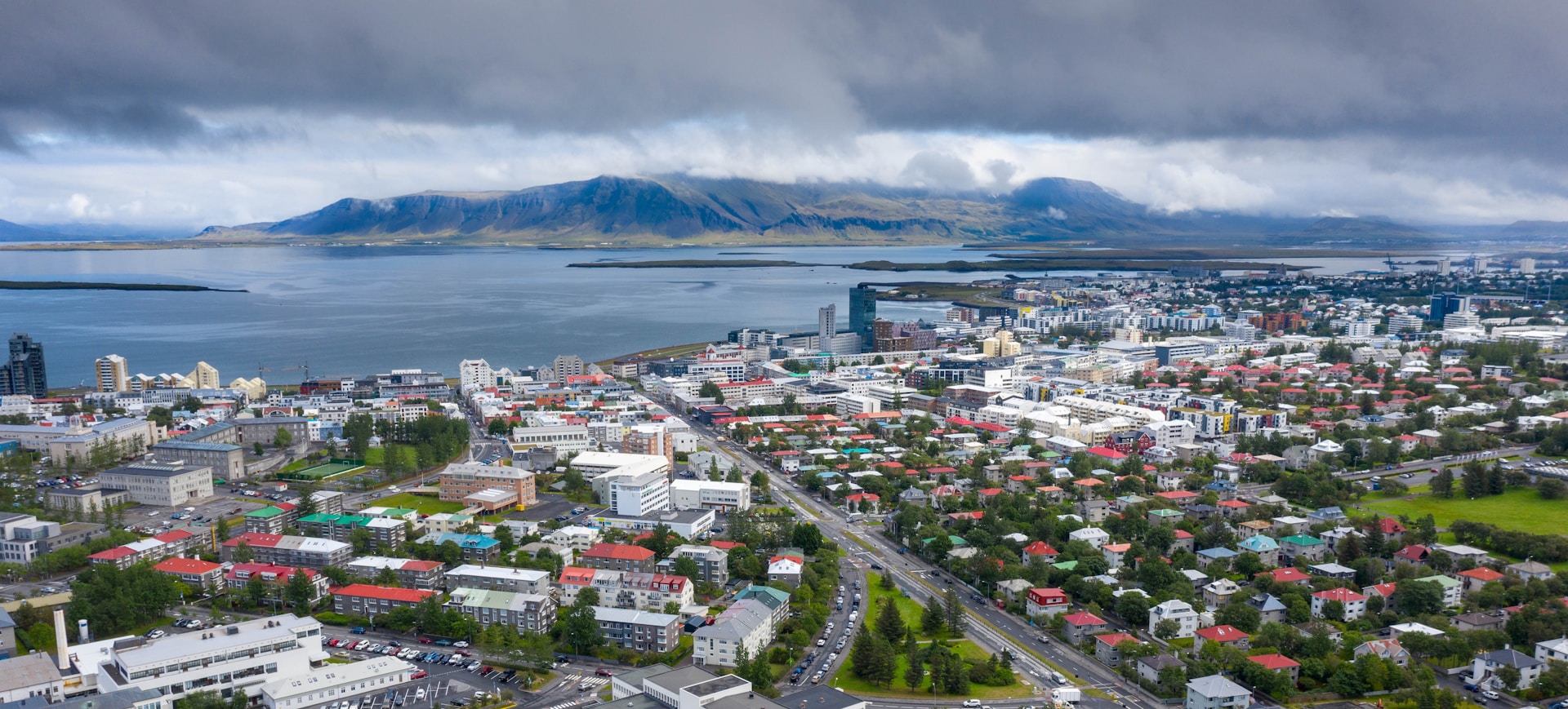 city near body of water under cloudy sky during daytime