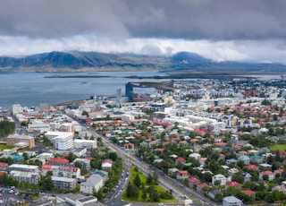 city near body of water under cloudy sky during daytime