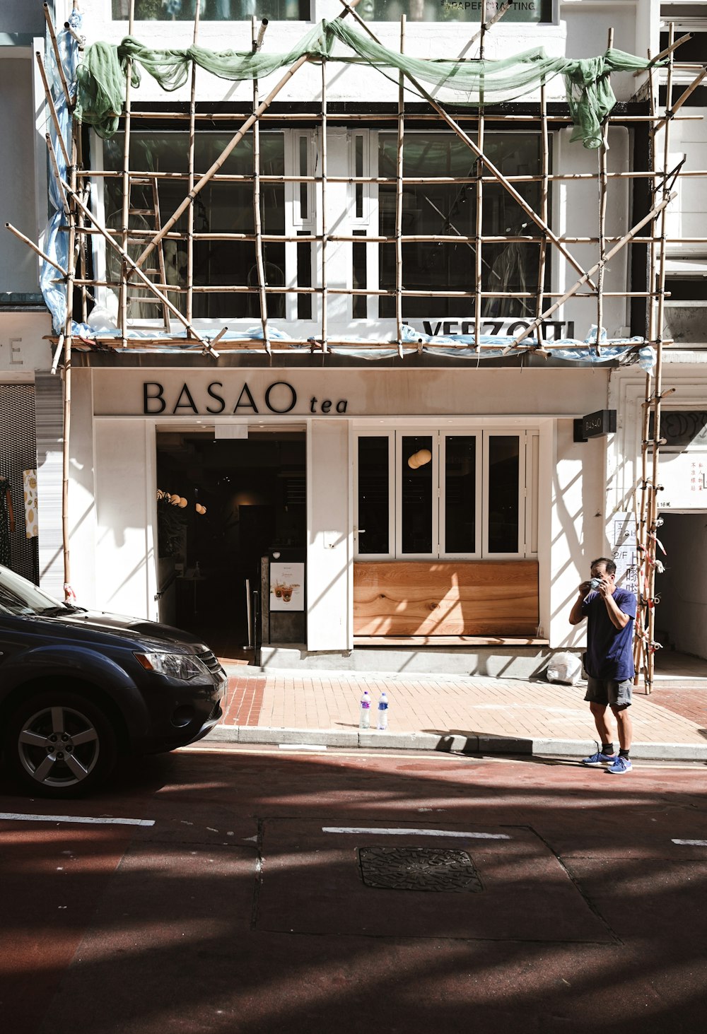 woman in blue jacket walking on sidewalk during daytime