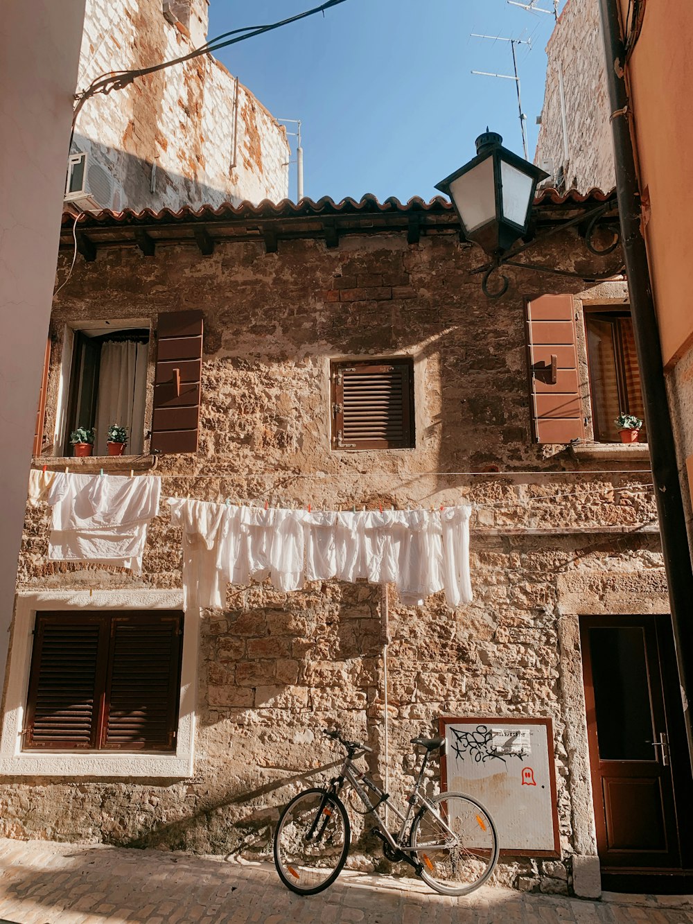 brown brick building with white window curtains