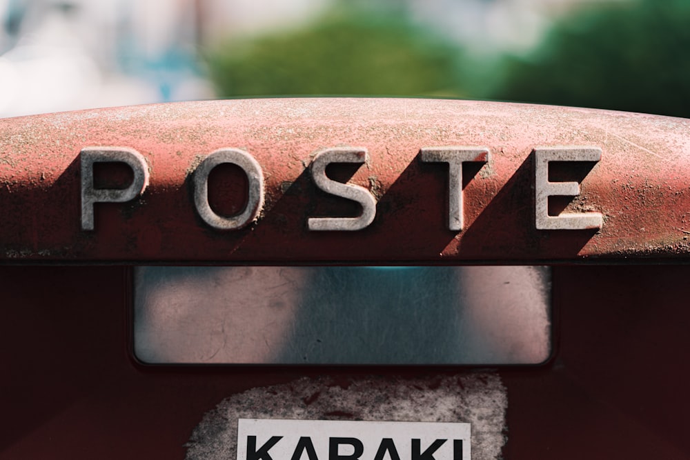 a close up of the word poste on the front of a red car