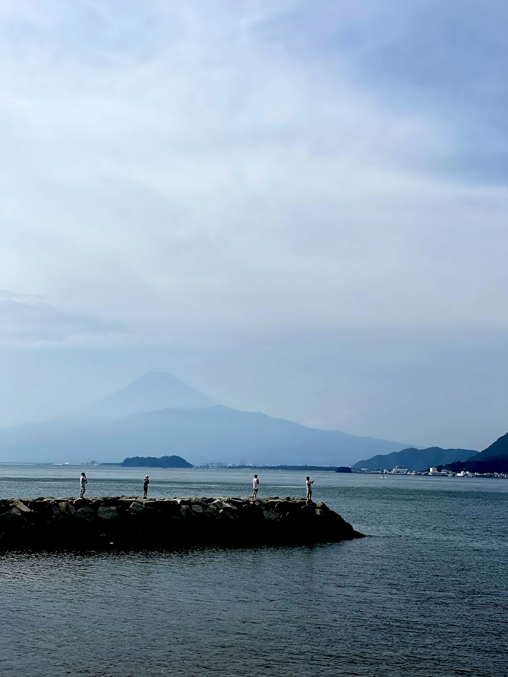 body of water near mountain during daytime