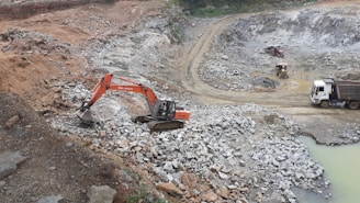 red and black excavator on rocky ground during daytime
