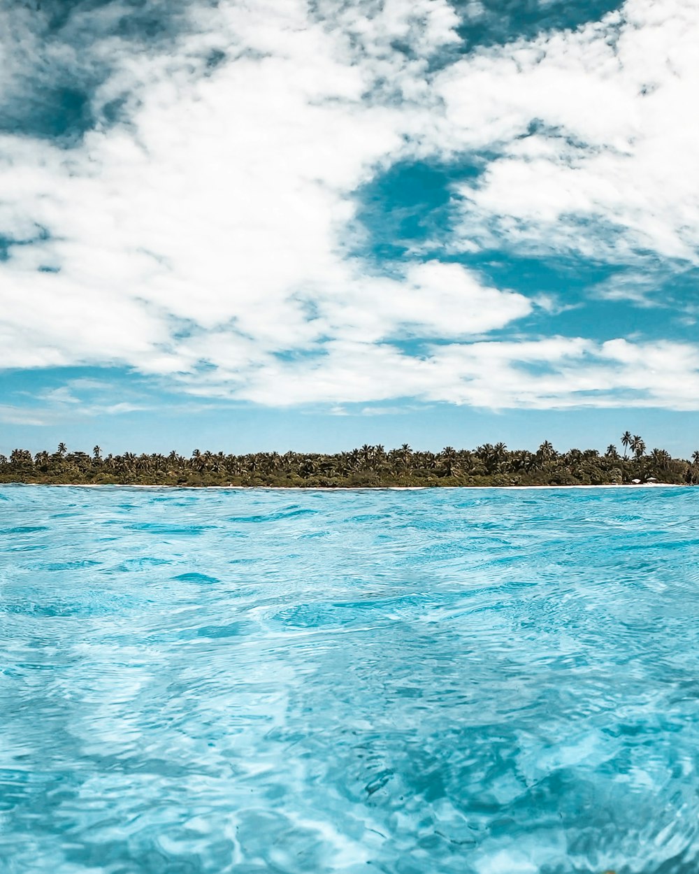 blue sea under blue sky and white clouds during daytime