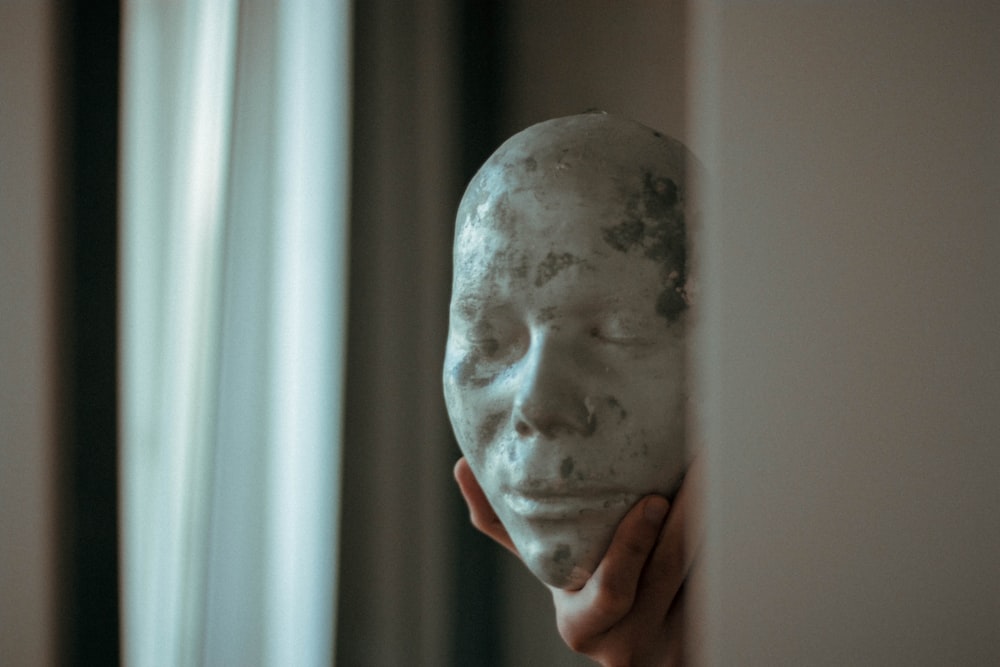 person holding white face mask