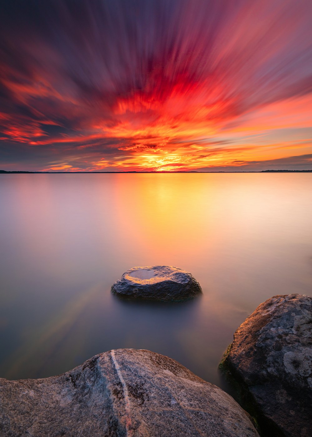 gray rock formation on body of water during sunset