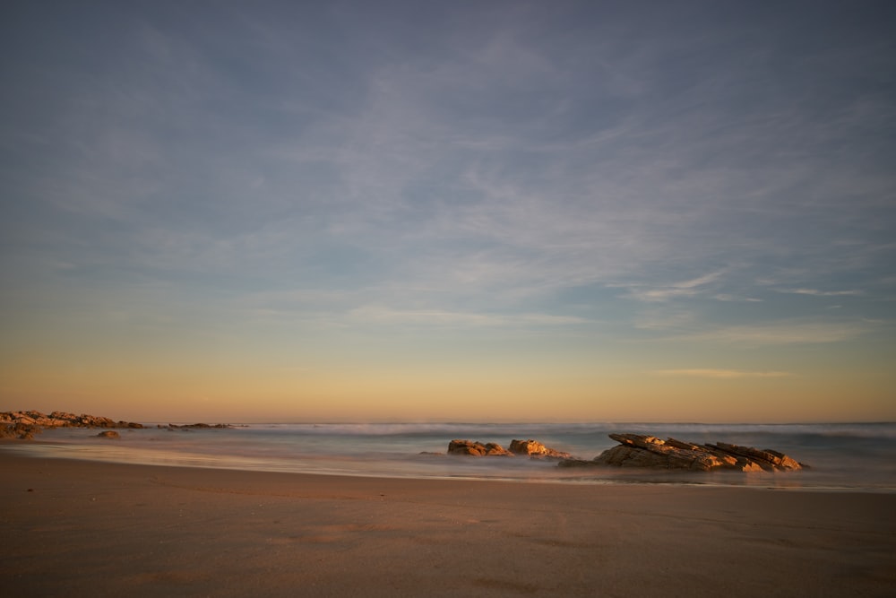 white and brown boat on sea shore during sunset