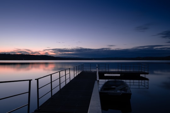 brown wooden dock on lake during daytime in Varese Italy