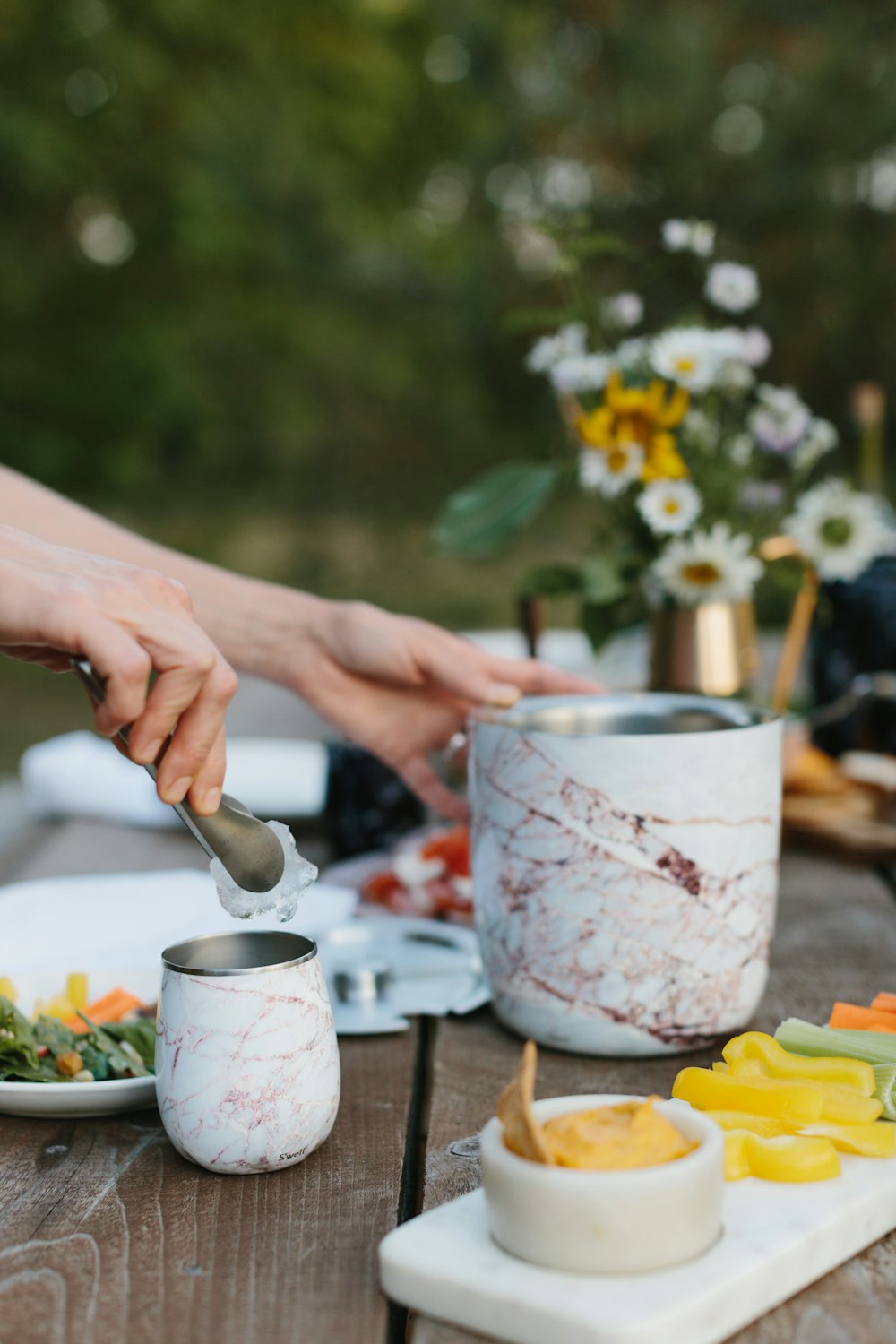 person holding silver spoon and white and red floral ceramic mug