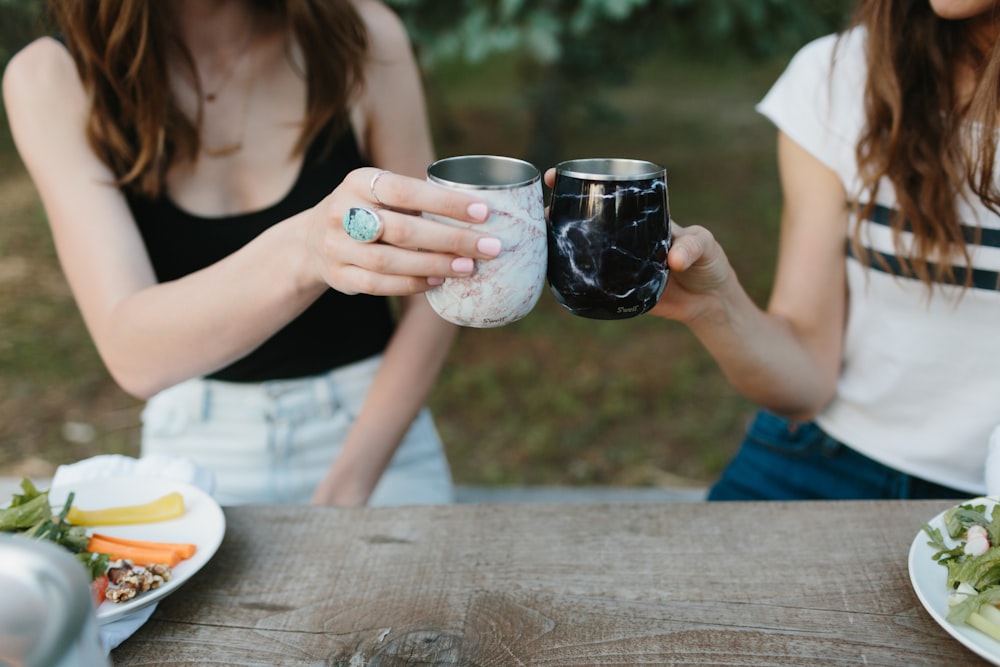 woman in white shirt holding clear glass mug