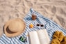 brown glass bottle beside white book on blue and white textile