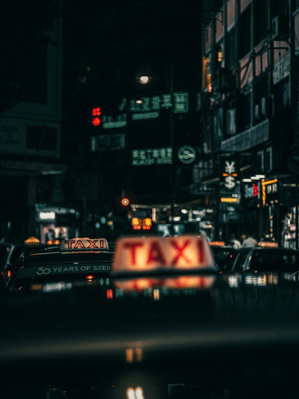 black and red taxi on road during night time
