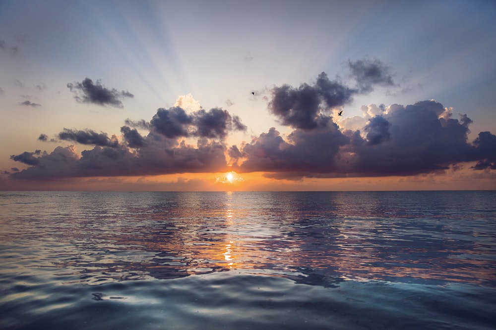 body of water under blue sky during sunset