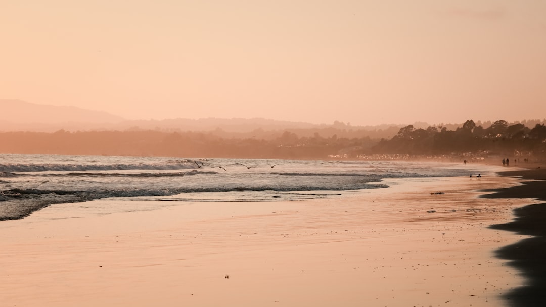 ocean waves crashing on shore during sunset