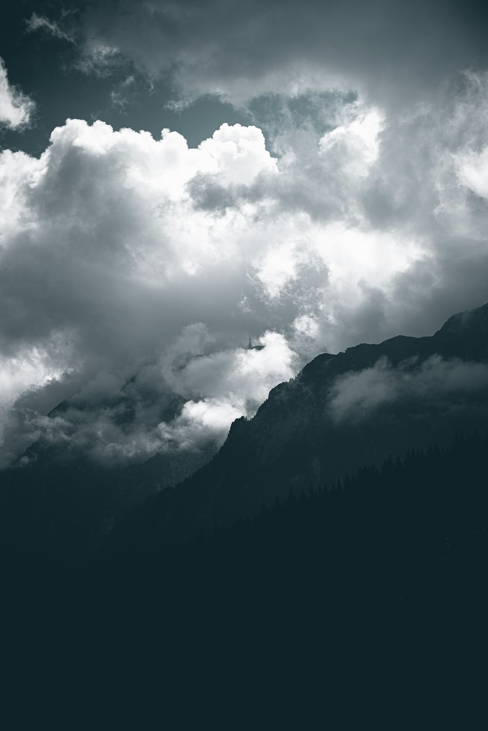 grayscale photo of mountain under cloudy sky