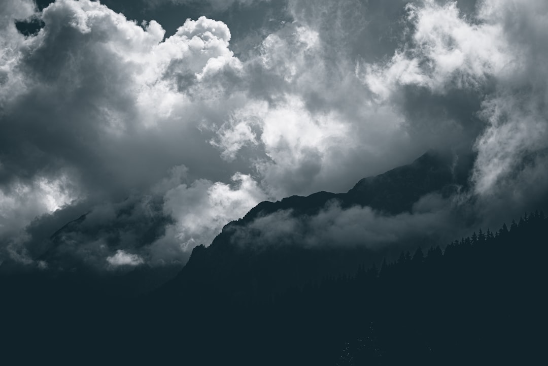 grayscale photo of clouds and mountain