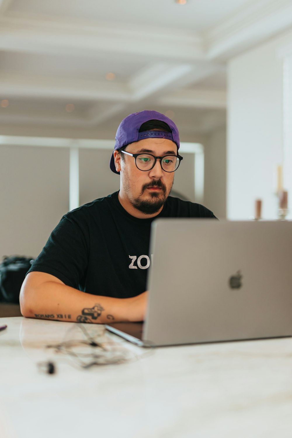 man in black crew neck t-shirt using macbook