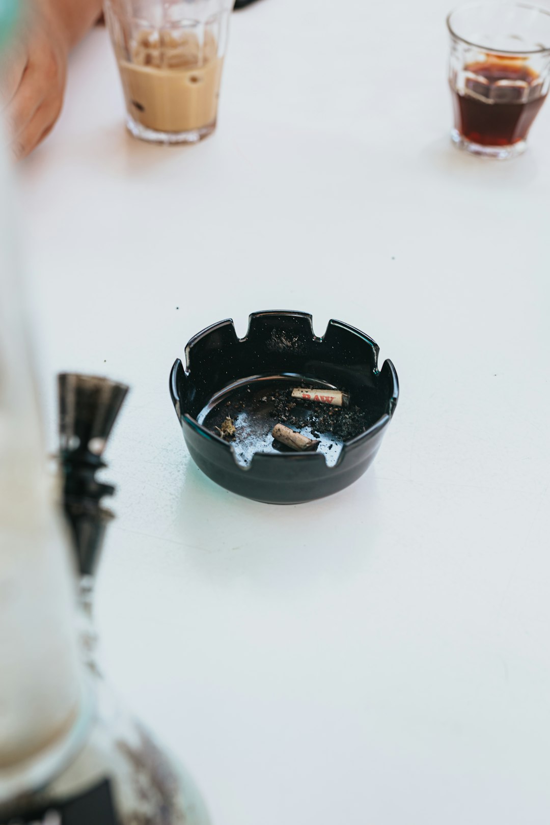 black ceramic ashtray on white table