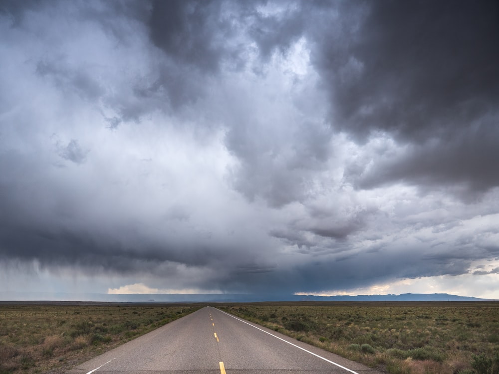 Carretera de asfalto gris bajo nubes grises