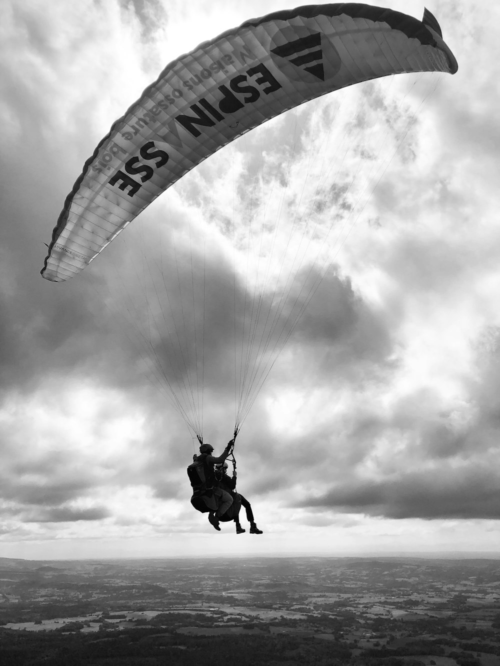 grayscale photo of man in parachute