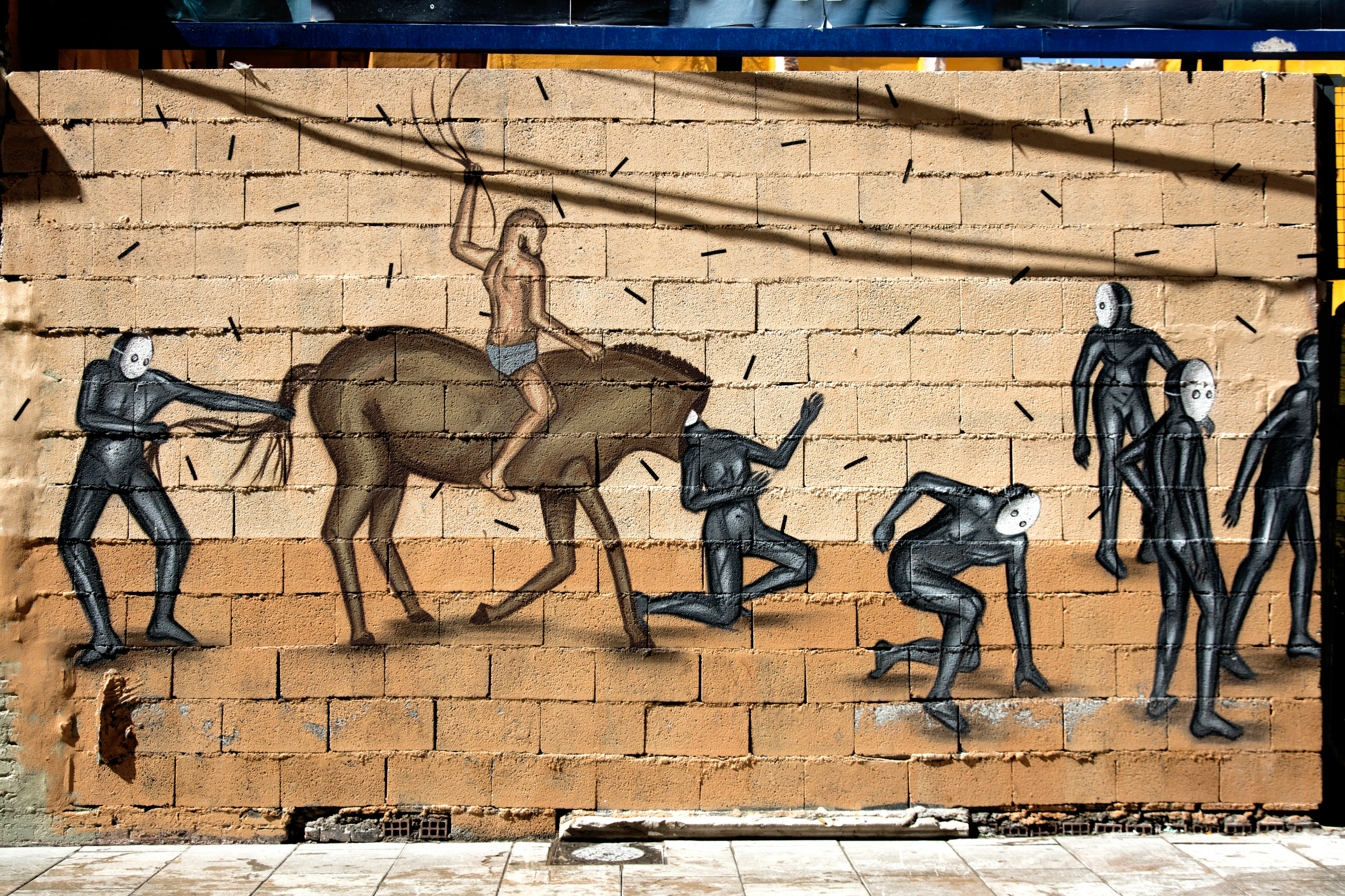 2 men jumping on brown concrete wall