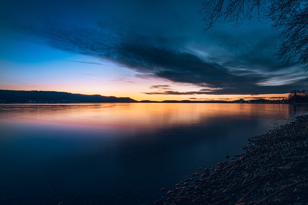 body of water under blue sky during sunset