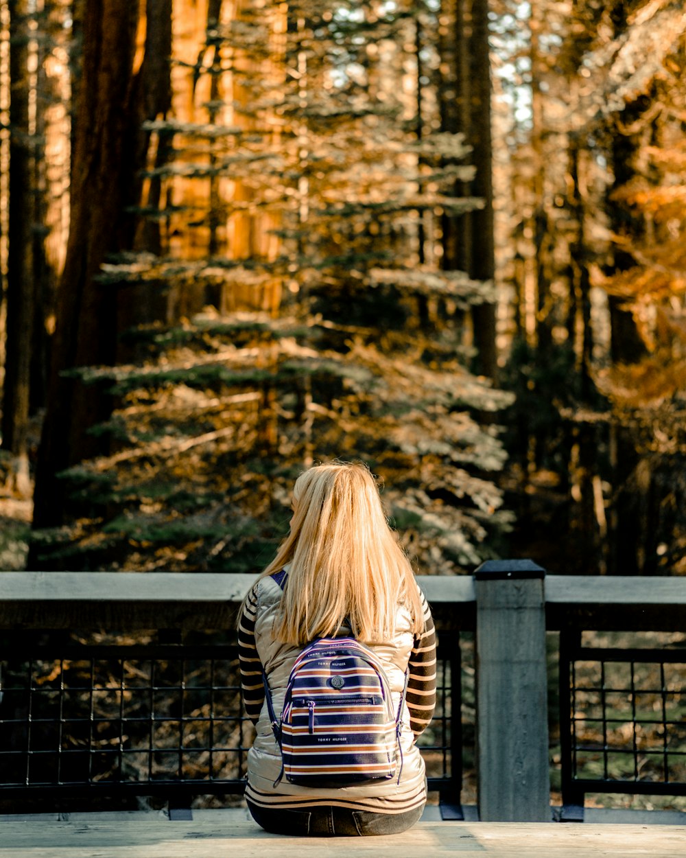 woman in black and white striped long sleeve shirt standing near brown wooden fence during daytime